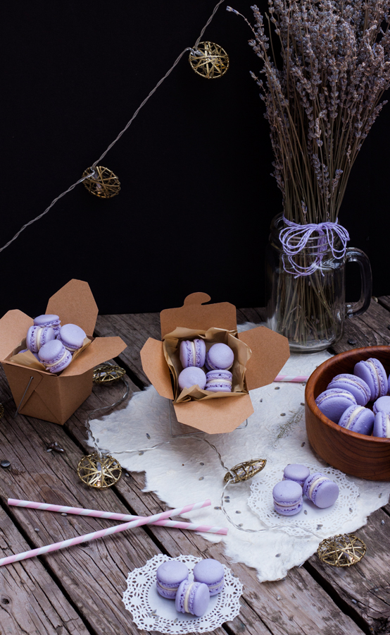 Mesa vintage con cajitas de comida para llevar llenas de mini macarons