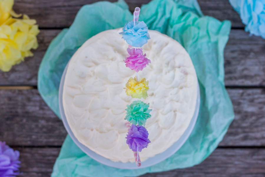 Acercamiento a una guirnalda de flores de papel que adornan un pastel de cumpleaños