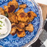 Plato con coliflor horneada a la paprika con un platito con ranch para acompañar a un lado para celebrar el Dia del Padre