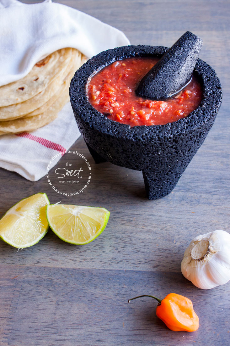Salsa Roja con Habanero en un molcajete de piedra y una servilleta de tela con tortillas de harina