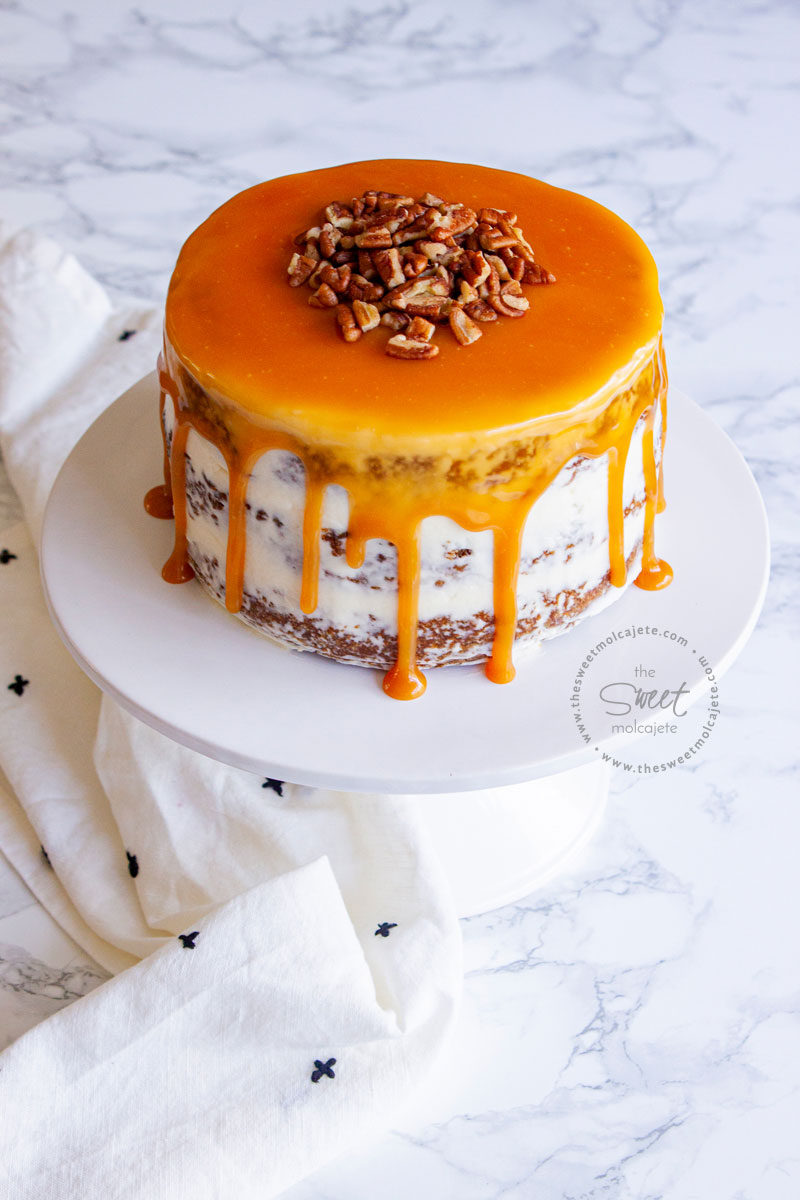 drip cake de zanahoria con caramelo y nueces en un cake stand blanco de ceramica